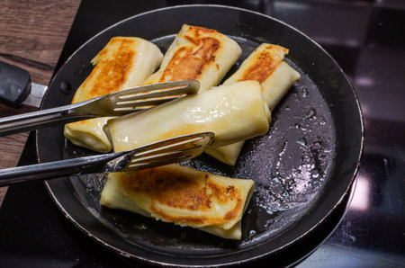 The cook is frying pancakes in a frying panの写真素材