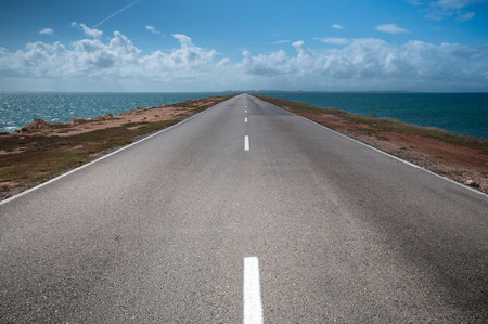 road stretches into the distance on both sides of the waterの写真素材