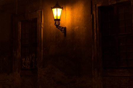 Old lantern illuminating a dark streetの写真素材