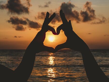hands make heart at the sunsetの写真素材