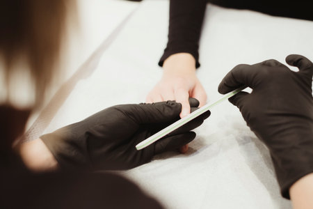 manicure in beauty center with black glovesの写真素材