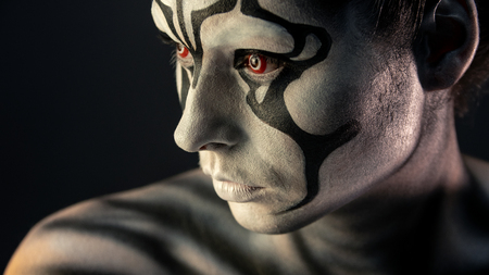 porter girl in the makeup of a mystical creature black white fiery red eyes, conceptual imageの写真素材