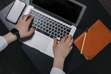 Top view of a mans hands typing on a laptopの写真素材