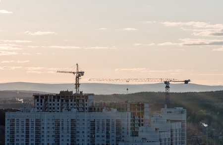 Tower crane against the sky in the afternoon. Backlight. Ekaterinburg, Russiaの写真素材