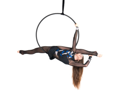 Young girl posing in an airy ring on a white background. Aerial hoop flyの写真素材