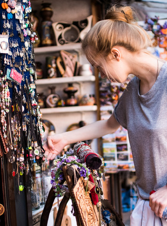 Woman choosing leather jewelry bracelets at the handmade craft marketの写真素材