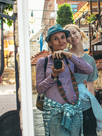 Two tourists take a selfie with the help of a mirror and a cameraの写真素材