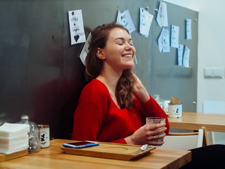 Beautiful young woman at table in coffee shop.の写真素材