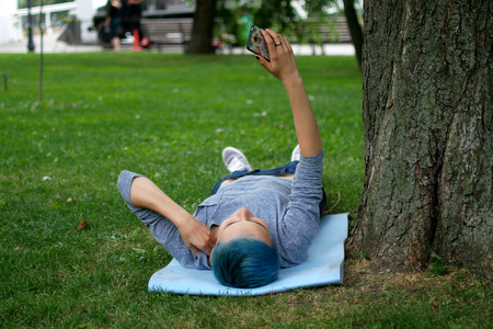 Phone woman laughing in talking in smart phone in park during spring summer. Happy smiling beautiful...