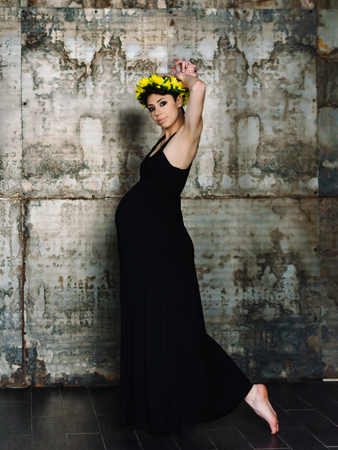 Studio fashion portrait of beautiful pregnant woman in black dress. Happy pregnancy. Beauty and health.の写真素材