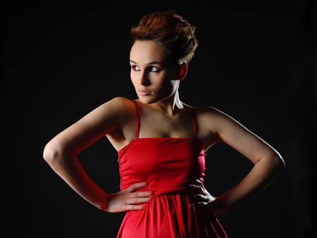 Sensual young lady in red dress posing an studio. Beauty, fashion conceptの写真素材