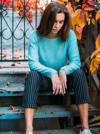 Portrait of a young beautiful woman. The girl on the background of golden autumn, calm and beautiful.の写真素材