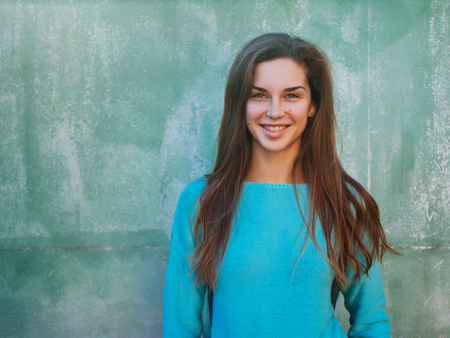 Portrait of a beautiful young caucasian girl. A woman in a blue sweater against the backdrop of a...