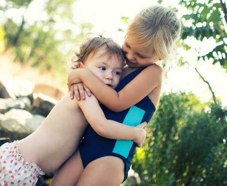 Two sisters hug. Family values, care for younger children.の写真素材