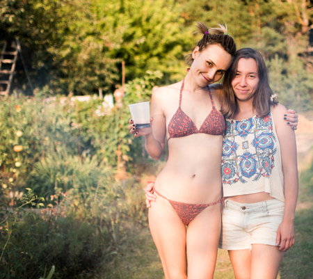 Photo of two friends at a summer picnic in a country house.の写真素材