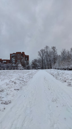 Track at snowed stadium of city park with multi story building on the backgroundの写真素材