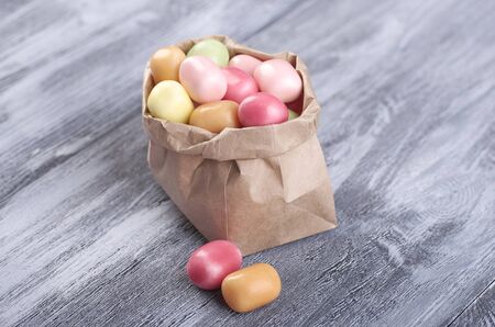 paper bag with gifts, toys and decorations on a wooden table top view. Copy space.の写真素材