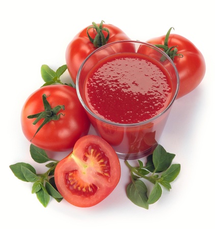 glass of tomato juice and fruits with green leaves isolated on whiteの写真素材