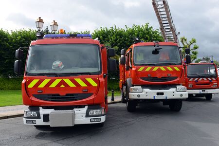 three fire trucks parked in the bay with all of the fire fighting equipment and gear ready to go