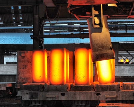 The crane removes forms from the heated steel pigs from a railway platform