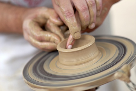 Hands working on pottery wheelの写真素材