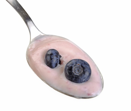 Spoon of yogurt with blueberry on top isolated on whiteの写真素材
