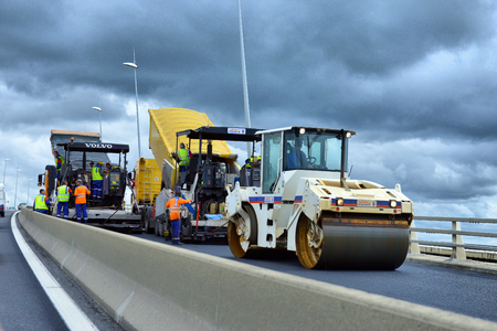 France - July 13 2012: On the job site - laying asphalt on the bridge of workers and road construction machinery on July 13 2012, Franceのeditorial素材