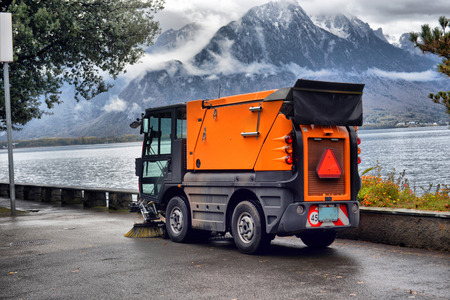 harvesting machine removes leaves on the waterfront of the alpine city