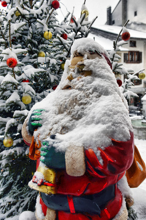 Santa Claus near the Christmas tree under the snowの写真素材