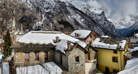 Beautiful panoramic view of historic mountain village on a scenic cold cloudy day with blue sky and clouds in winter, Italian regionの写真素材