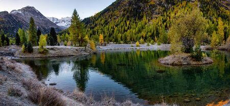 Autumn landscape with reflection in a lake in the alpine mountainsÑŽ Autumn scenery of colorful...