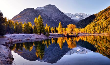 Autumn landscape with reflection in a lake in the alpine mountainsÑ Autumn scenery of colorful trees reflected in lake waterの写真素材