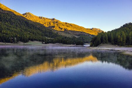 Mountain lake panorama with mountains reflection. Idyllic look. Autumn forest. Silvaplana Lake,...