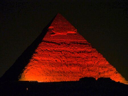 A great pyramid at Giza lit up with red light during the evening night show.の写真素材