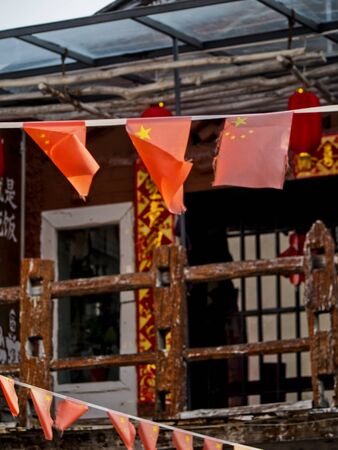 Strands of Chinese flags hang in front of a bar in the old city of Dali China.の写真素材