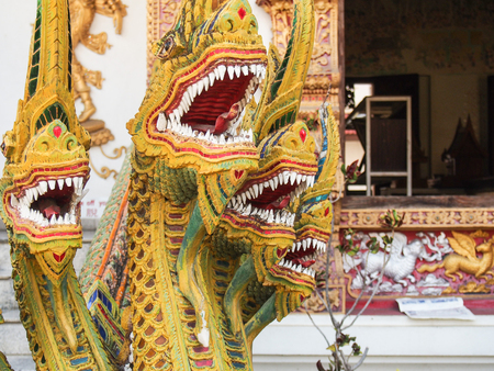Bright yellow multi-headed dragon sculpture at a temple in Chiang Mai Thailand.の写真素材