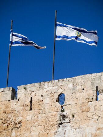 Flags fly over the wall surrounding the old city of Jerusalem, Israel.の写真素材