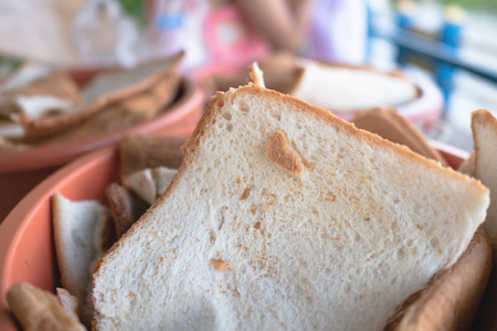 Bread in orange bucket To feed fish, a fragment of bread, cake, or crackerの写真素材