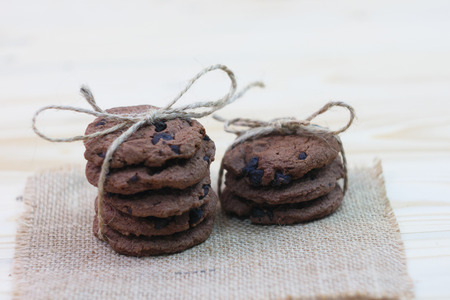 Chocolate chip cookies are tied in a row to gift on a wooden tableの写真素材