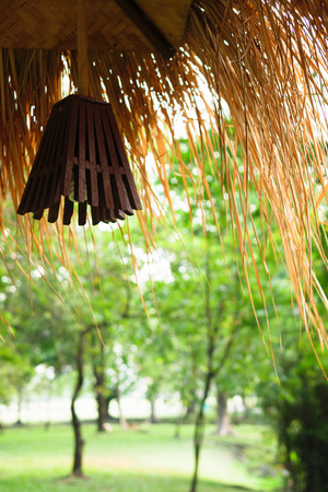 Hanging lanterns at the corner of the cottage in the forest, with a beautiful green tree background. Use for backgroundの写真素材