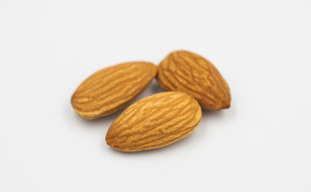 three almond seeds on white background. Select focus shallow depth of field.の写真素材