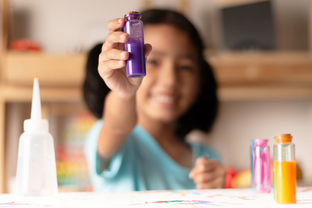 Asian gril is showing purple in glass from testing with smile and happiness. Select focus shallow depth of field and blurred background.の写真素材