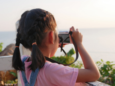 Asian girl holding camera taking a picture with travelling in nature.