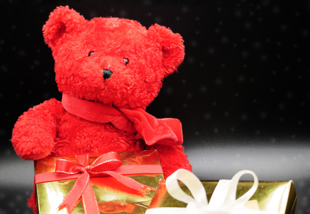 Teddy bear and gift boxes with snow black background.の写真素材