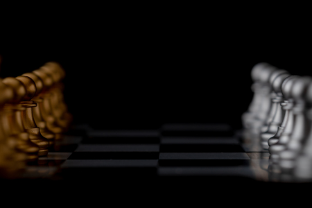 Gold and silver chess endways on the board. Select focus shallow depth of field and blurred background.の写真素材