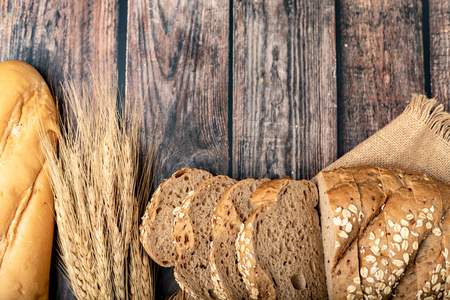 breads sliced and wheat on the sack with a wooden table