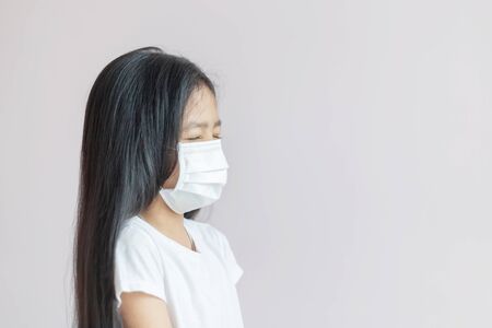 Asian little girl wearing a protective medical mask. The protection for the epidemic of the flu, Coronavirus or COVID-19 and illness with smog.の写真素材