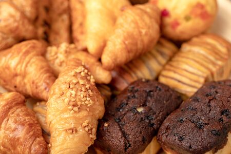 Croissant groups and bakery in wood bowl on the wooden tableの写真素材