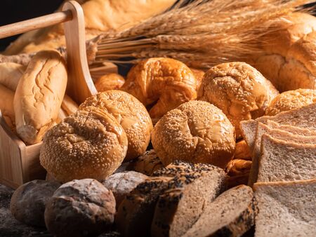 A variety of bread put together in a pile. Close-up a group of bread on the wooden table with...