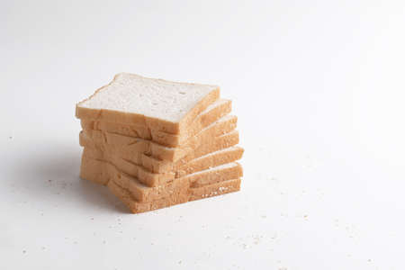 Slice of bread on the white background. Breads are a food made from wheat flour mixed with water and...